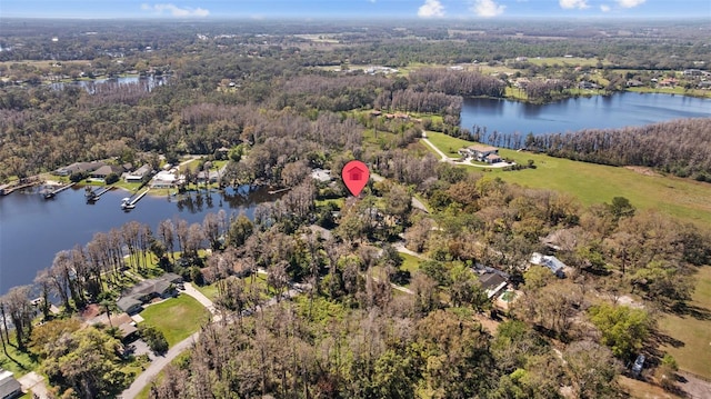 birds eye view of property with a water view and a view of trees