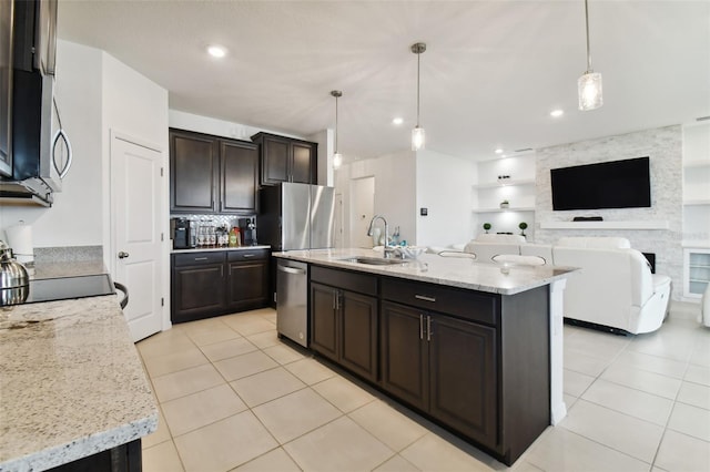 kitchen featuring light tile patterned floors, light stone counters, appliances with stainless steel finishes, dark brown cabinets, and a sink