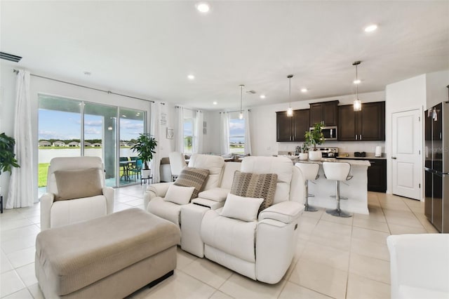 living area with light tile patterned floors, visible vents, and recessed lighting