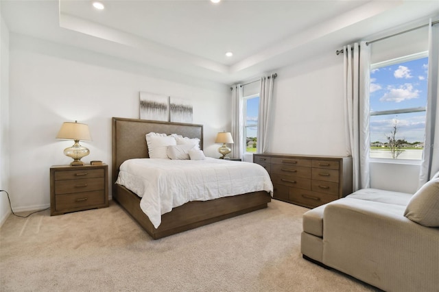 bedroom featuring a tray ceiling, light colored carpet, and recessed lighting