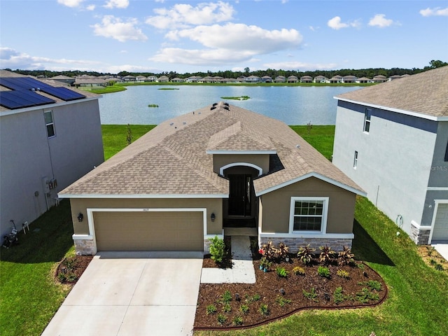 view of front facade featuring stone siding, a water view, driveway, and a front yard