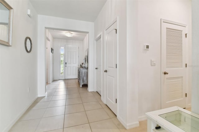 hall with baseboards and light tile patterned floors