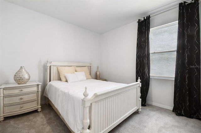 bedroom featuring baseboards, multiple windows, and carpet