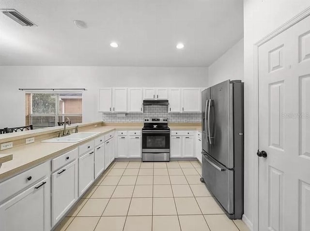 kitchen featuring under cabinet range hood, a sink, visible vents, light countertops, and appliances with stainless steel finishes