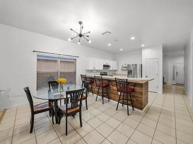 dining area with light tile patterned floors, recessed lighting, a notable chandelier, visible vents, and baseboards