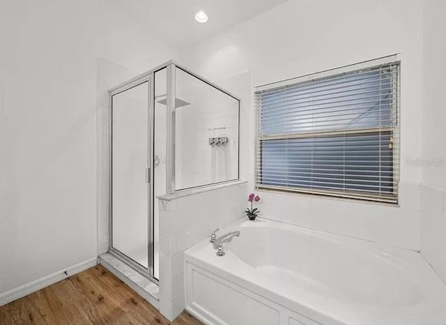 bathroom with a garden tub, recessed lighting, a stall shower, wood finished floors, and baseboards