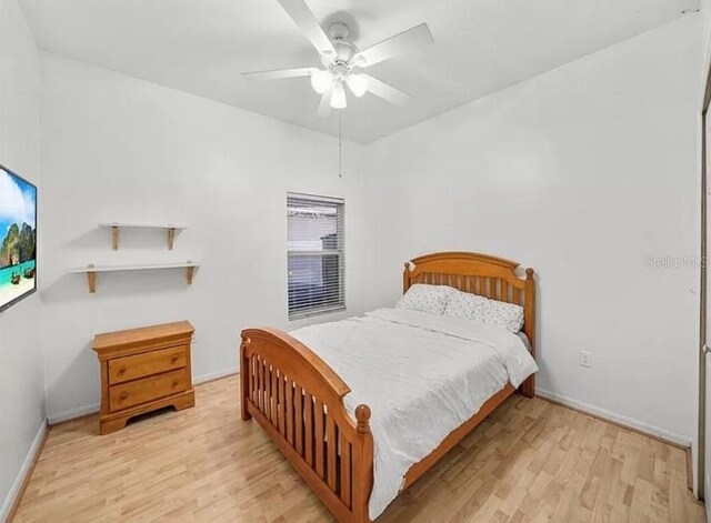 bedroom with light wood finished floors, baseboards, and a ceiling fan