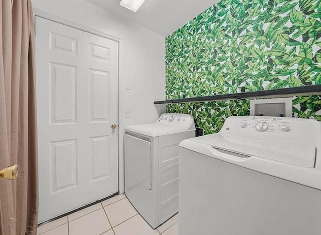 washroom featuring laundry area, light tile patterned floors, wallpapered walls, and separate washer and dryer