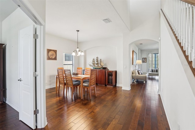 dining room featuring arched walkways, visible vents, dark wood finished floors, and baseboards