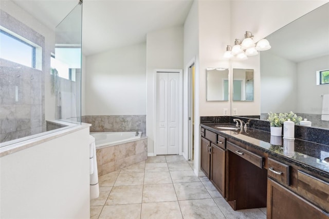 bathroom featuring tile patterned floors, plenty of natural light, a bath, and vanity