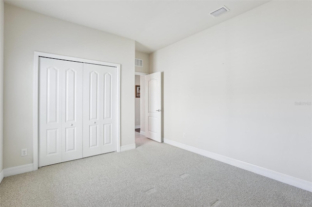 unfurnished bedroom featuring carpet, a closet, visible vents, and baseboards