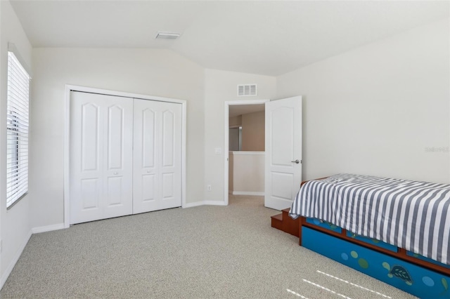 bedroom with visible vents, baseboards, vaulted ceiling, a closet, and carpet