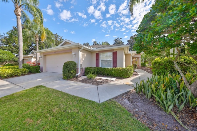 ranch-style house featuring a garage, concrete driveway, a front lawn, and stucco siding