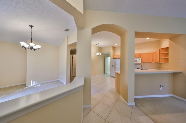 interior space with arched walkways, open shelves, visible vents, an inviting chandelier, and white appliances