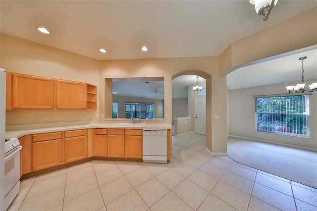 kitchen with arched walkways, light countertops, an inviting chandelier, a sink, and white appliances