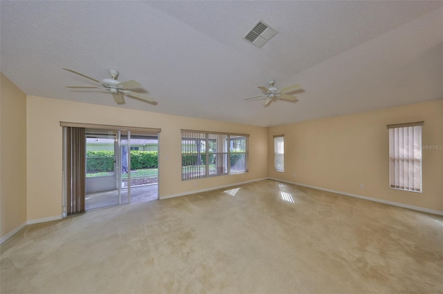 spare room featuring light carpet, plenty of natural light, visible vents, and a ceiling fan