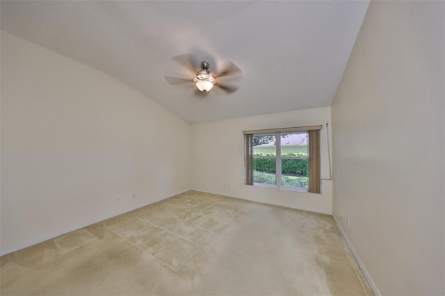 unfurnished room with lofted ceiling, a textured ceiling, and light colored carpet