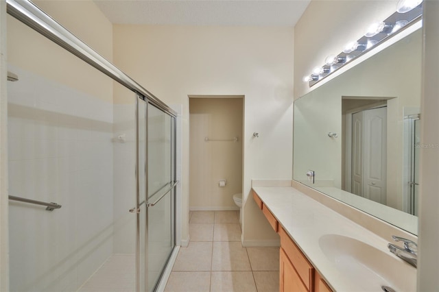 full bathroom featuring toilet, a stall shower, vanity, and tile patterned floors