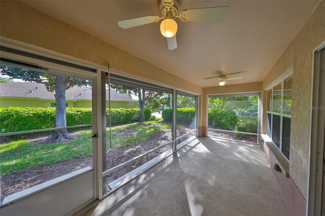 unfurnished sunroom with ceiling fan