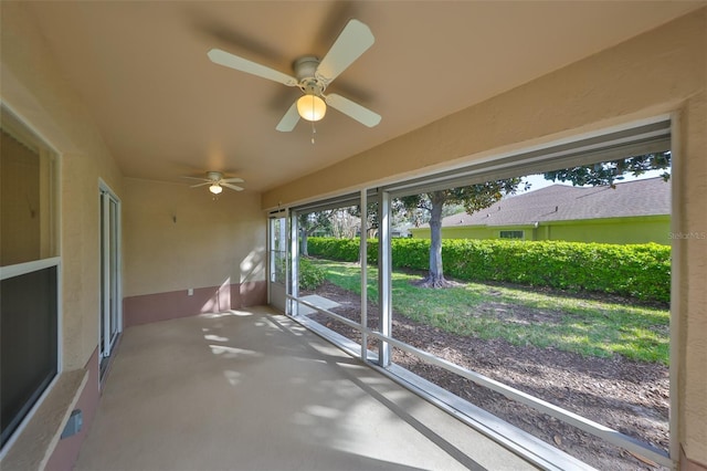 unfurnished sunroom with a ceiling fan