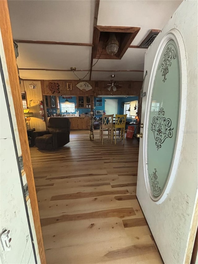 interior space with a ceiling fan, wood finished floors, and visible vents