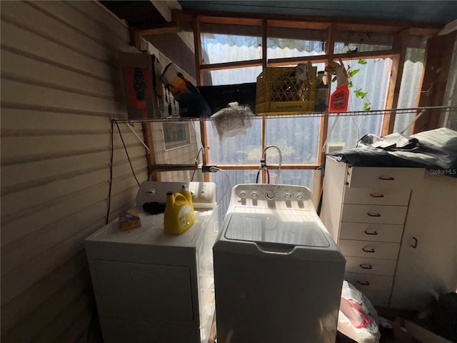 interior space featuring laundry area, wooden walls, and washing machine and dryer