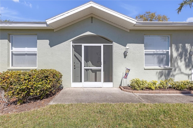 view of exterior entry with stucco siding