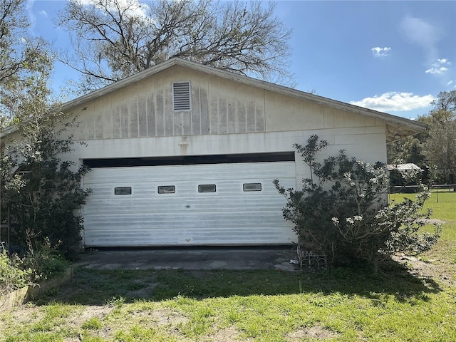 view of side of property featuring a garage, an outbuilding, and a yard