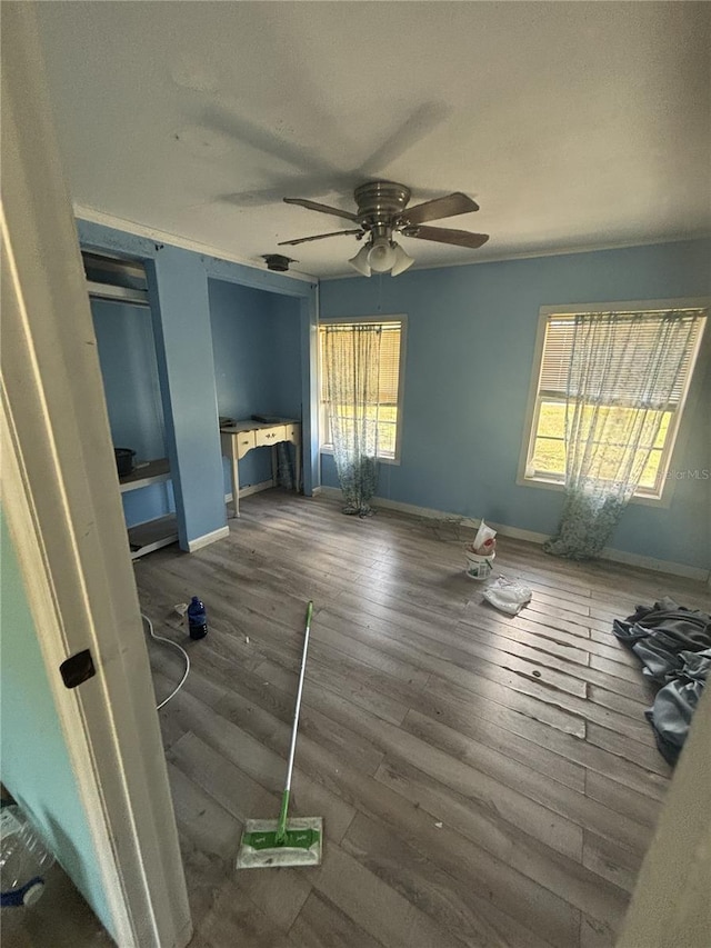 interior space with ceiling fan, baseboards, and hardwood / wood-style floors