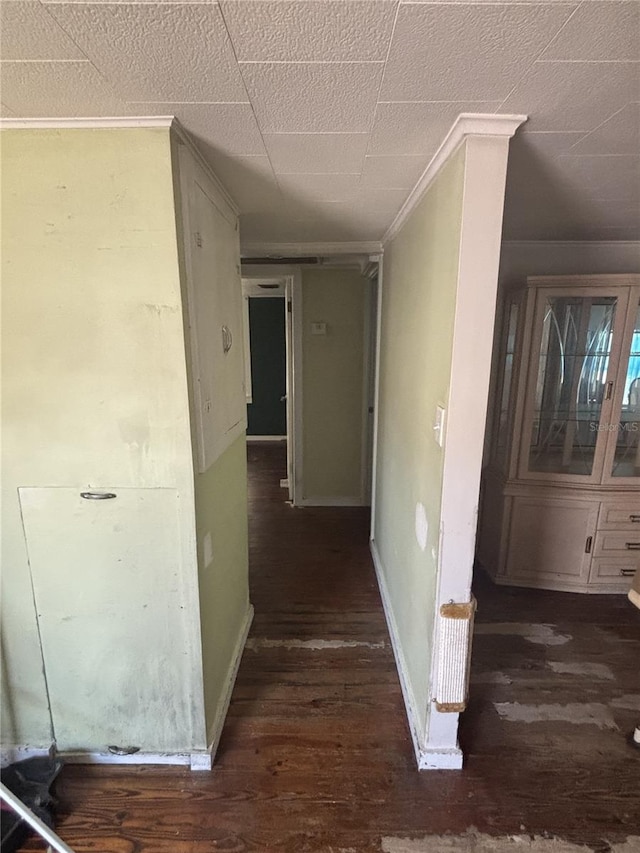 corridor with baseboards, wood finished floors, and ornamental molding