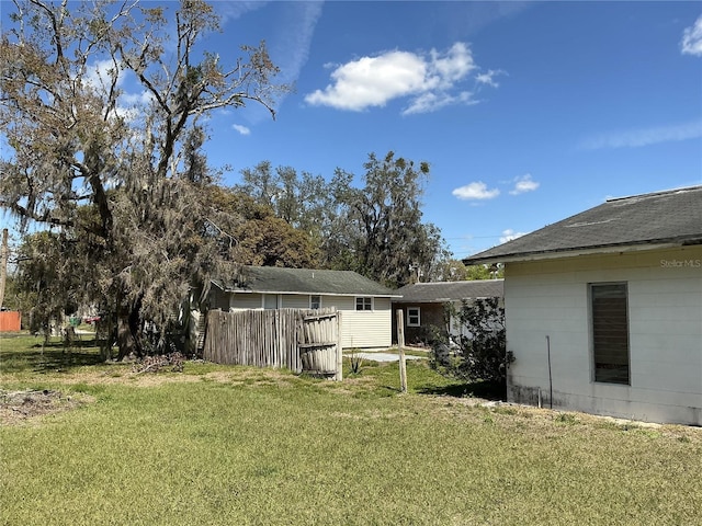 rear view of property with a lawn and fence