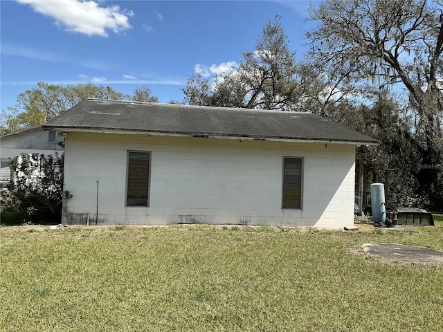 view of home's exterior with a yard and concrete block siding