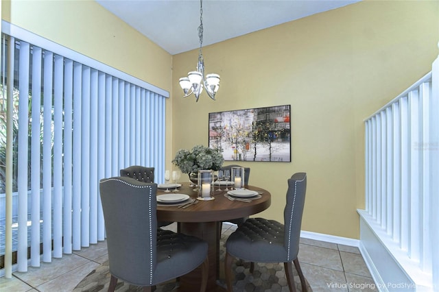 dining area with tile patterned flooring, baseboards, and a notable chandelier