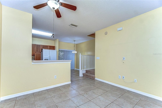 unfurnished room with visible vents, a textured ceiling, baseboards, and light tile patterned floors