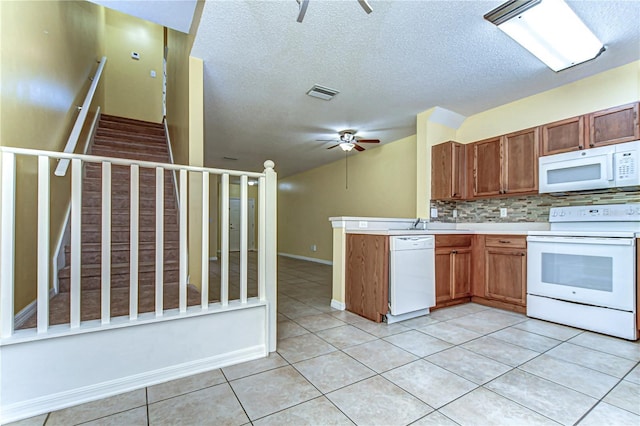 kitchen featuring white appliances, light tile patterned floors, visible vents, ceiling fan, and backsplash