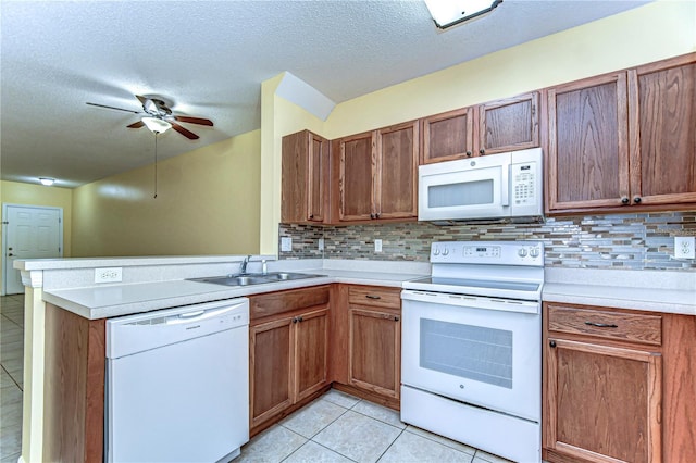 kitchen with tasteful backsplash, light countertops, light tile patterned flooring, white appliances, and a peninsula