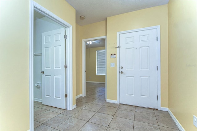 corridor with baseboards and light tile patterned flooring