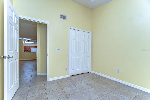 unfurnished bedroom with a closet, visible vents, baseboards, and light tile patterned floors