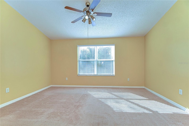 carpeted empty room featuring a ceiling fan, baseboards, and a textured ceiling