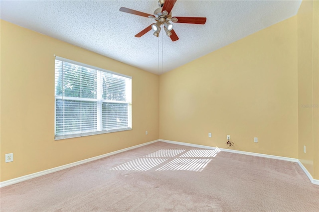 unfurnished room with a textured ceiling, ceiling fan, carpet flooring, and baseboards