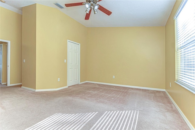 unfurnished room with light carpet, baseboards, visible vents, a ceiling fan, and high vaulted ceiling