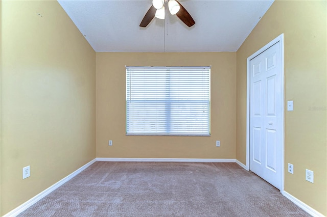 unfurnished room with carpet floors, baseboards, and a ceiling fan