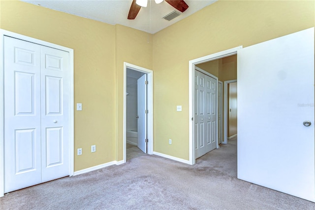 unfurnished bedroom featuring baseboards, visible vents, ensuite bath, ceiling fan, and carpet flooring