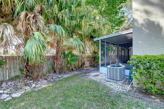 view of yard featuring a sunroom, fence, and cooling unit