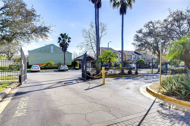 view of street with curbs and a gated entry