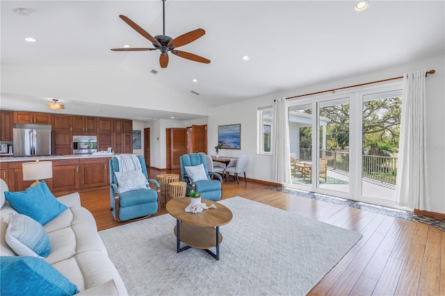 living area with lofted ceiling, recessed lighting, visible vents, light wood-style flooring, and baseboards