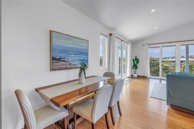 dining space featuring light wood-style floors, recessed lighting, and vaulted ceiling