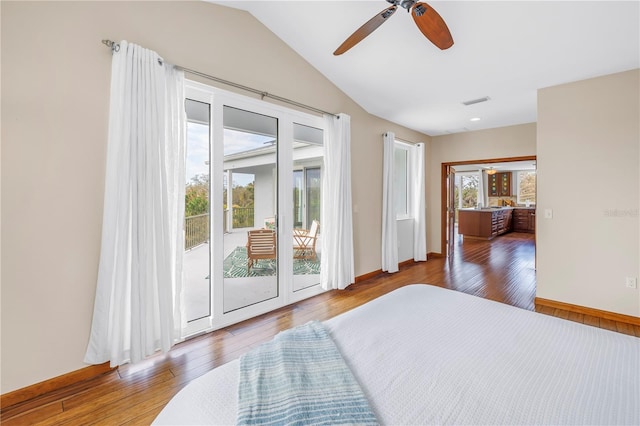 bedroom with lofted ceiling, access to exterior, multiple windows, and hardwood / wood-style floors