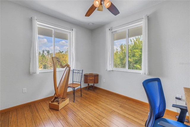 office featuring light wood-style floors, baseboards, and a ceiling fan