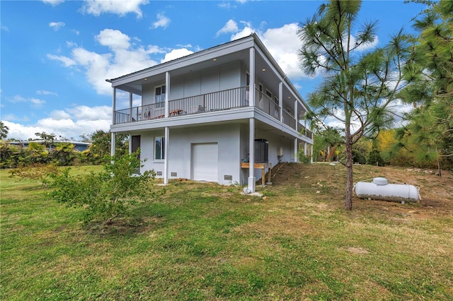 back of house with a balcony, a yard, and stucco siding